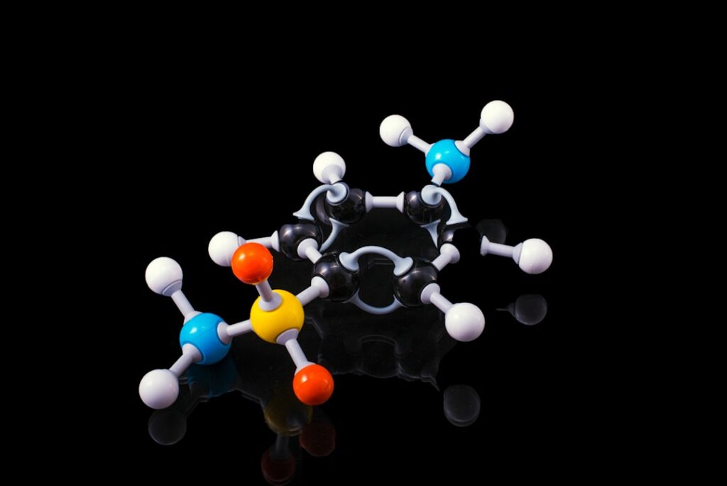 3D molecular model depicting a chemical compound with colorful atoms on a black background