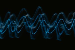 abstract visualization of sound waves in blue light against a black background